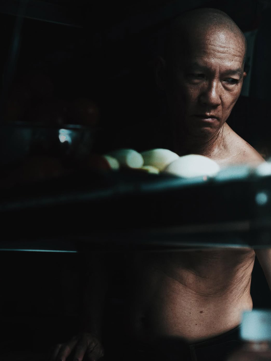 a portrait of a man who is selling noodle on the street.